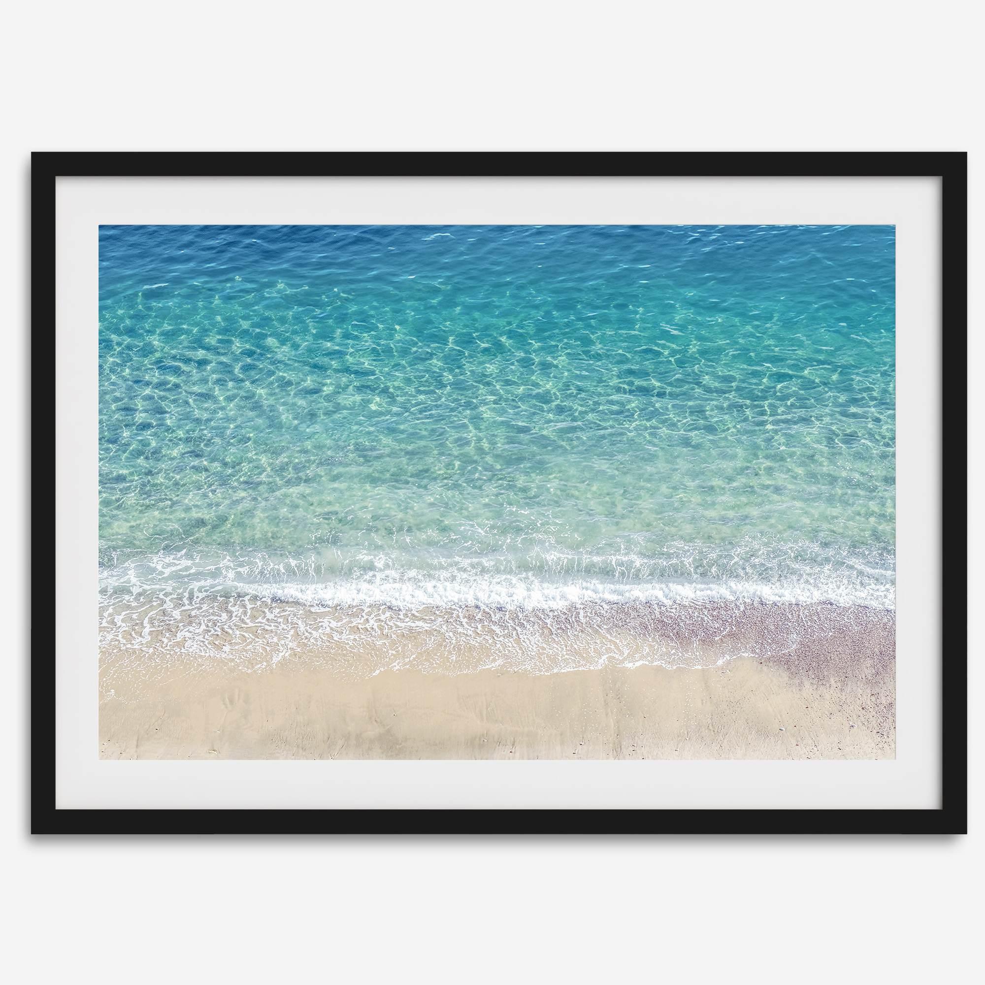 This fine art aerial beach print showcases the mesmerizing colors of the ocean in vivid detail. From the deep blue depths to the vibrant greenish turquoise blue, transitioning to the golden sandy beach and the crashing white surf.