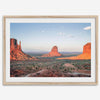 A fine art landscape photography print of a desert sunset over Monument Valley, located on the Arizona-Utah border. The warm and vibrant hues of this American Southwest sunset create a mesmerizing and awe-inspiring scene.