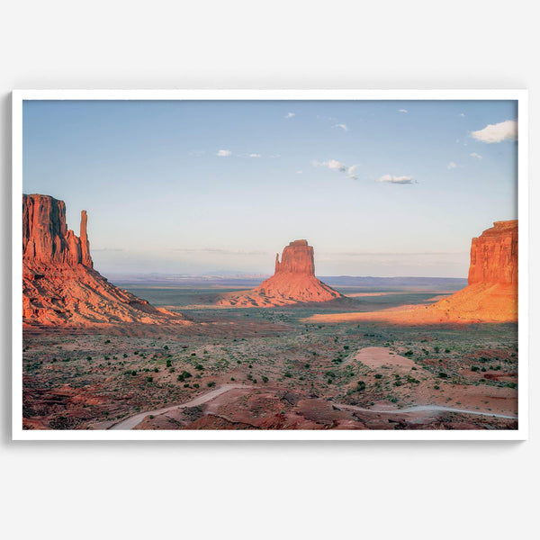 A fine art landscape photography print of a desert sunset over Monument Valley, located on the Arizona-Utah border. The warm and vibrant hues of this American Southwest sunset create a mesmerizing and awe-inspiring scene.