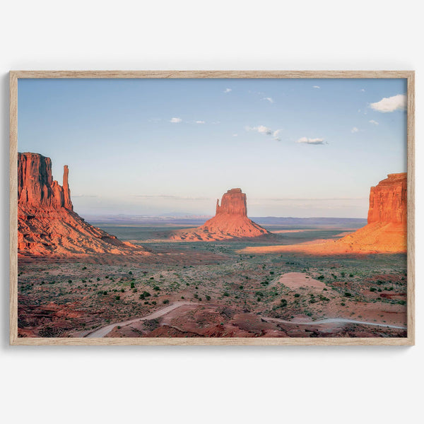 A fine art landscape photography print of a desert sunset over Monument Valley, located on the Arizona-Utah border. The warm and vibrant hues of this American Southwest sunset create a mesmerizing and awe-inspiring scene.