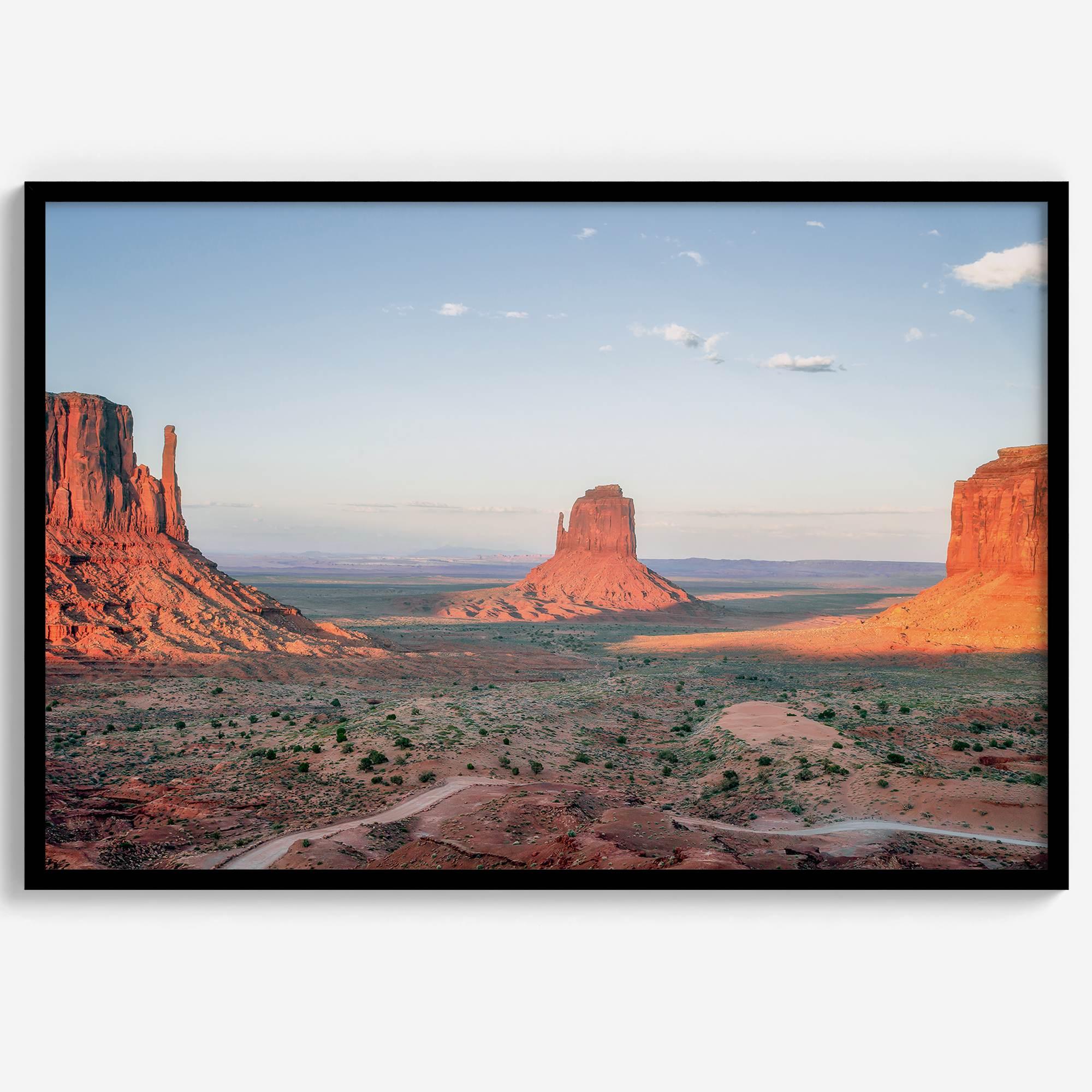 A fine art landscape photography print of a desert sunset over Monument Valley, located on the Arizona-Utah border. The warm and vibrant hues of this American Southwest sunset create a mesmerizing and awe-inspiring scene.