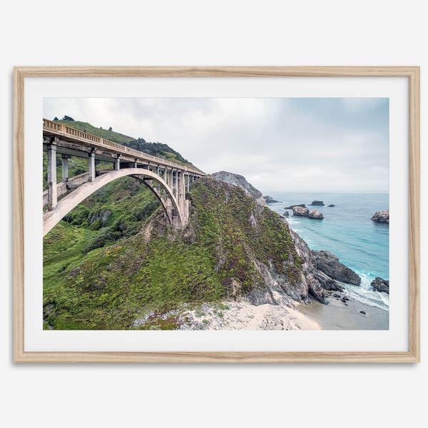 A fine art ocean print of one of the most iconic spots in the famous Route 1 in California - Bixby Bridge near Big Sur. Shot in a unique wide angle that captures the bridge, cliffs, the ocean, and the stunning beach below.