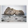 Fine art print showcasing a magnificent rock formation framing the horizon and crashing waves, with scattered rocks adding texture. Captivating and soothing, this print is a timeless addition to any space, evoking relaxation and awe-inspiring beauty.