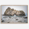 Fine art print showcasing a magnificent rock formation framing the horizon and crashing waves, with scattered rocks adding texture. Captivating and soothing, this print is a timeless addition to any space, evoking relaxation and awe-inspiring beauty.