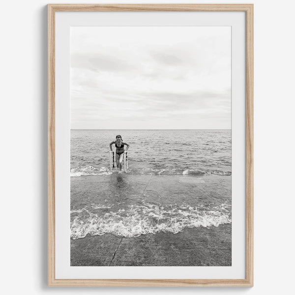 A black and white fine art lake beach print of a beach in Chicago on the coast of Lake Michigan showcasing a woman bathing in the lake. The classic modern look of the print is sure to impress when hung on your walls.