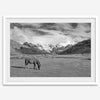 A black and white mountain horse fine art print that can come framed on unframed and was taken in Peru. This mountain wall art showcases snow-covered mountains in Peru and a charming horse grazing relaxingly in the forefront of the picture.