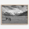 A black and white mountain horse fine art print that can come framed on unframed and was taken in Peru. This mountain wall art showcases snow-covered mountains in Peru and a charming horse grazing relaxingly in the forefront of the picture.