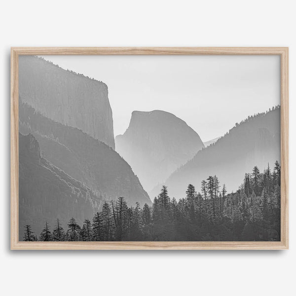 A black and white photography wall art of Yosemite Valley at sunset, featuring the iconic Half Dome and El Capitan bathed in dramatic light and shadow. Perfect for nature lovers and art enthusiasts.