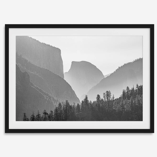A black and white photography wall art of Yosemite Valley at sunset, featuring the iconic Half Dome and El Capitan bathed in dramatic light and shadow. Perfect for nature lovers and art enthusiasts.