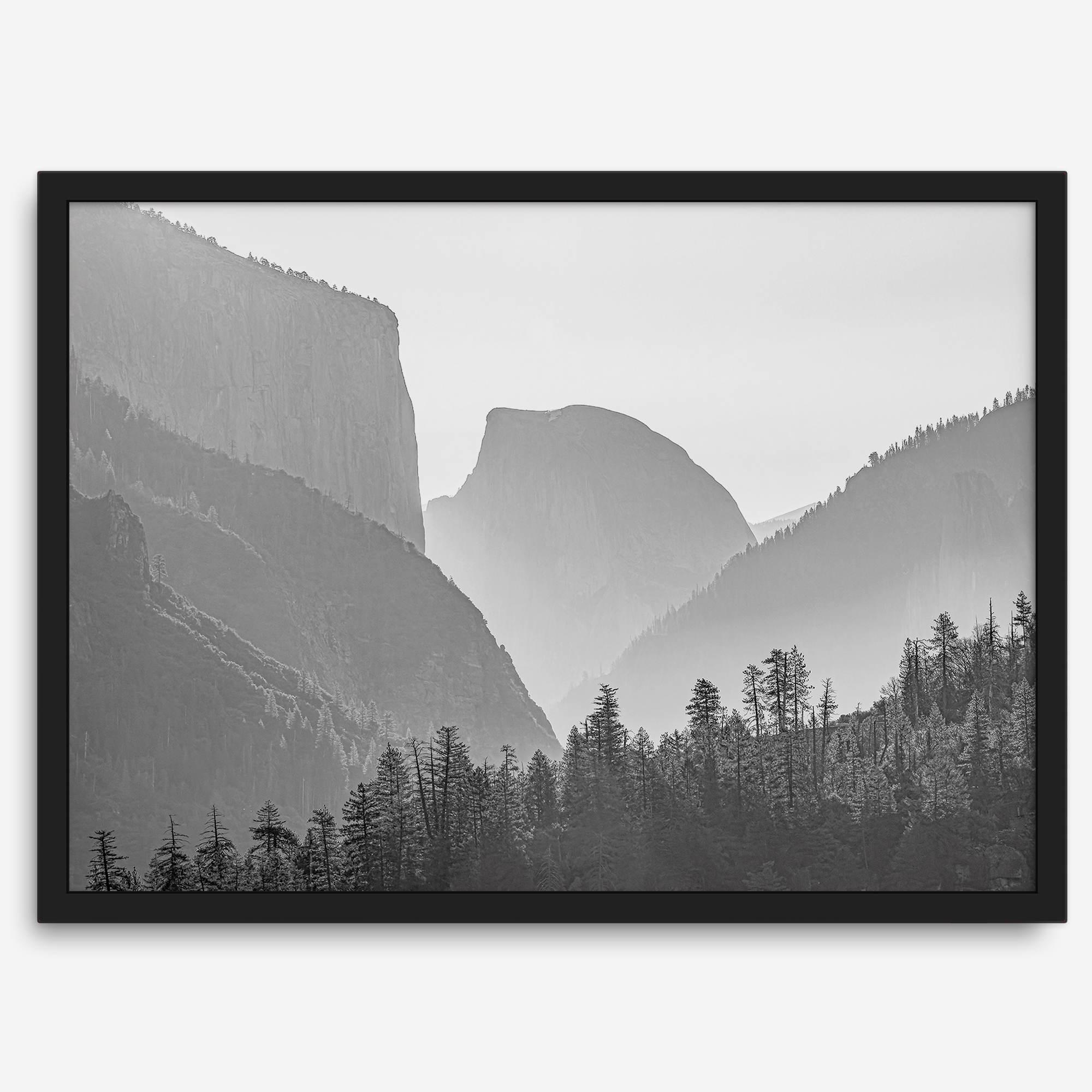 A black and white photography wall art of Yosemite Valley at sunset, featuring the iconic Half Dome and El Capitan bathed in dramatic light and shadow. Perfect for nature lovers and art enthusiasts.