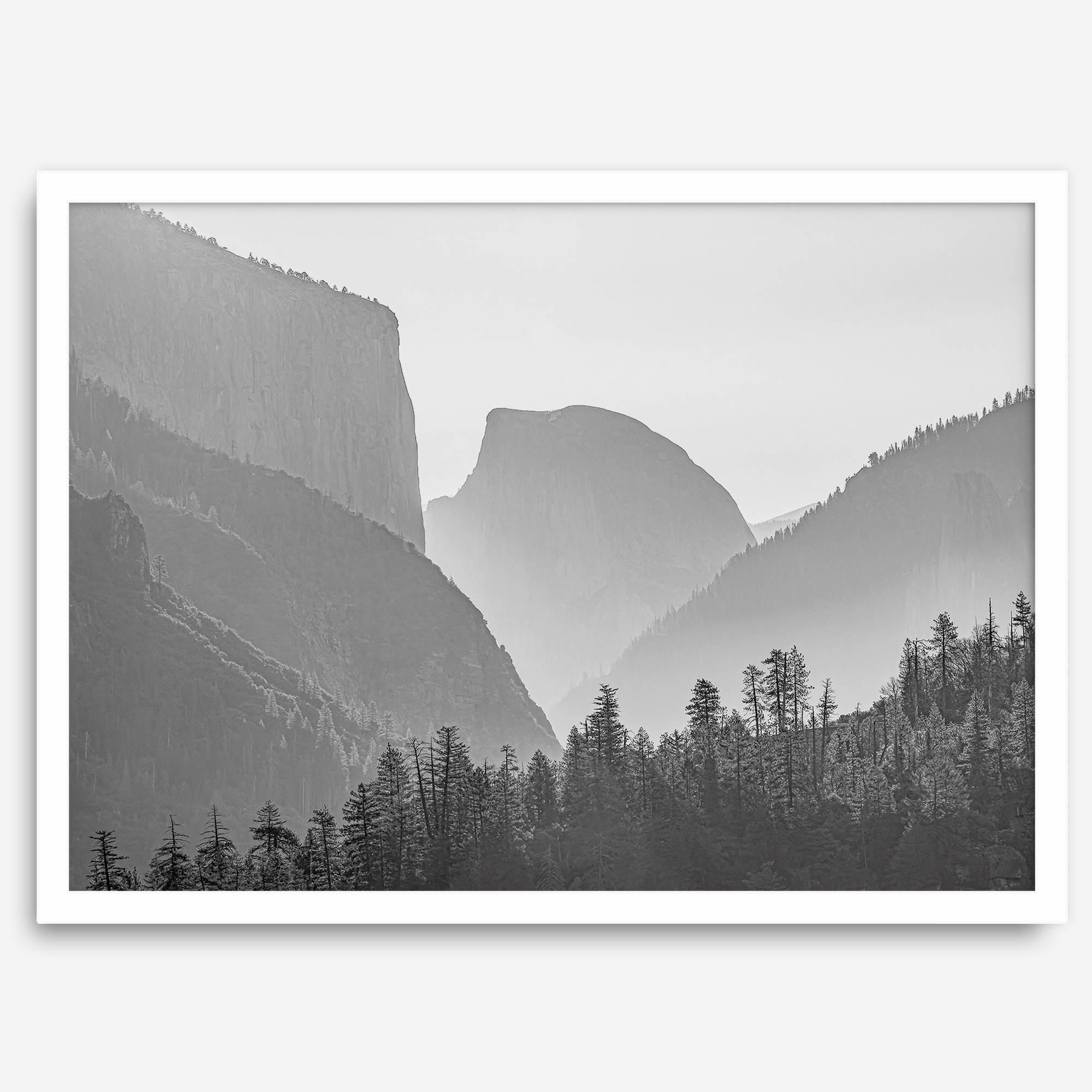 A black and white photography wall art of Yosemite Valley at sunset, featuring the iconic Half Dome and El Capitan bathed in dramatic light and shadow. Perfect for nature lovers and art enthusiasts.
