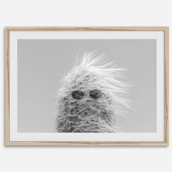 Black-and-white cactus print featuring a windswept cool cactus with sunglasses in a minimalist desert setting.