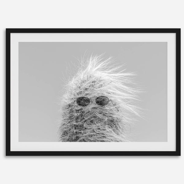 Black-and-white cactus print featuring a windswept cool cactus with sunglasses in a minimalist desert setting.