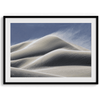 Fine art photo of Mesquite Flat Sand Dunes in Death Valley at golden hour. Windblown sand creates textured patterns across the immense dunes, bathed in warm light.
