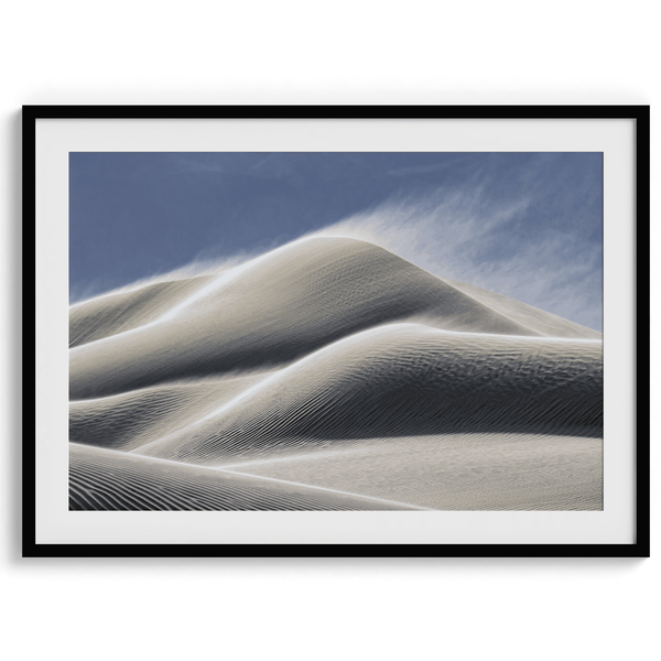 Fine art photo of Mesquite Flat Sand Dunes in Death Valley at golden hour. Windblown sand creates textured patterns across the immense dunes, bathed in warm light.
