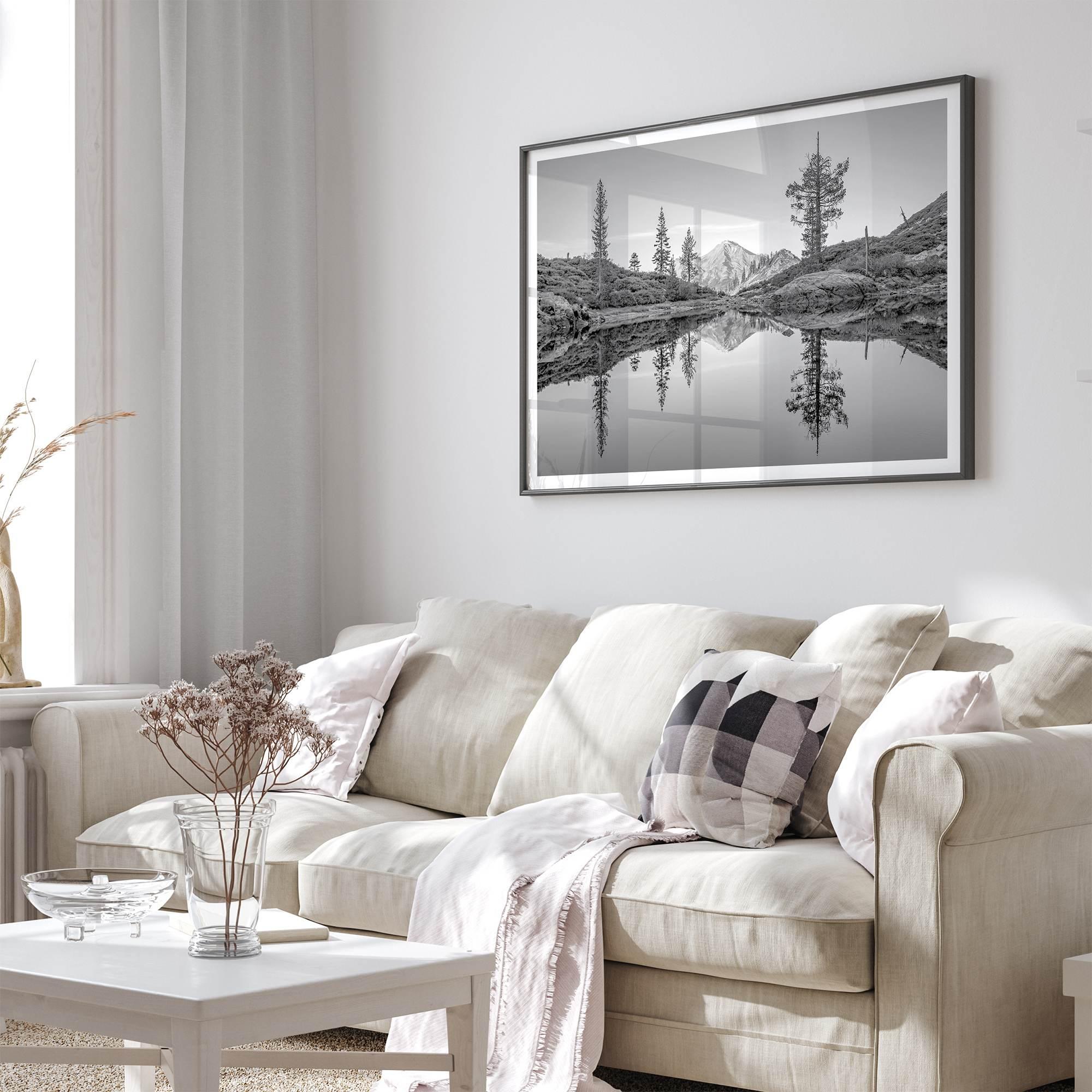 Black and white fine art photo of a serene mountain and forest mirrored in a still lake at sunset.