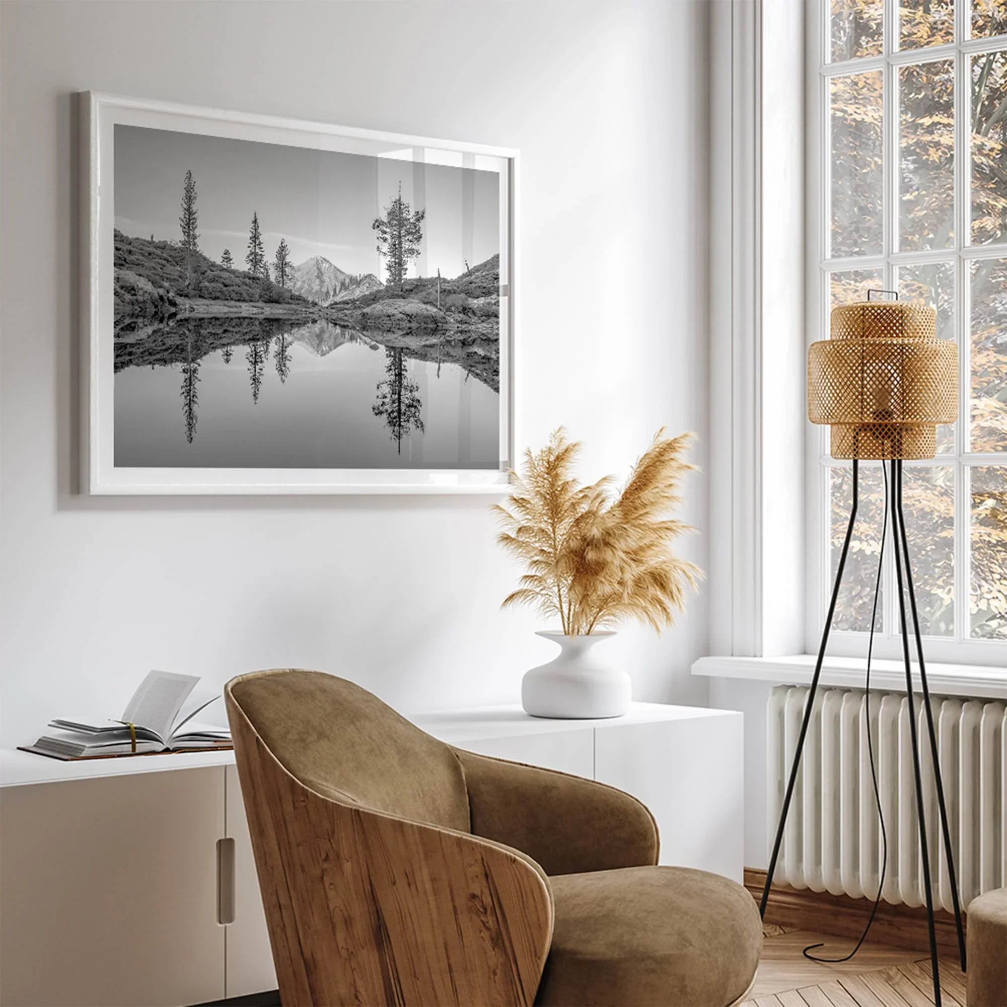 Black and white fine art photo of a serene mountain and forest mirrored in a still lake at sunset.