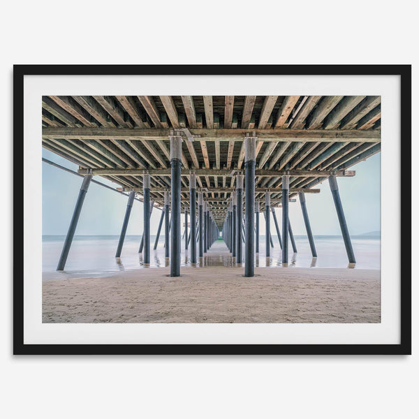 A fine art boho style beach photography print featuring a view from below Pismo Beach Pier.