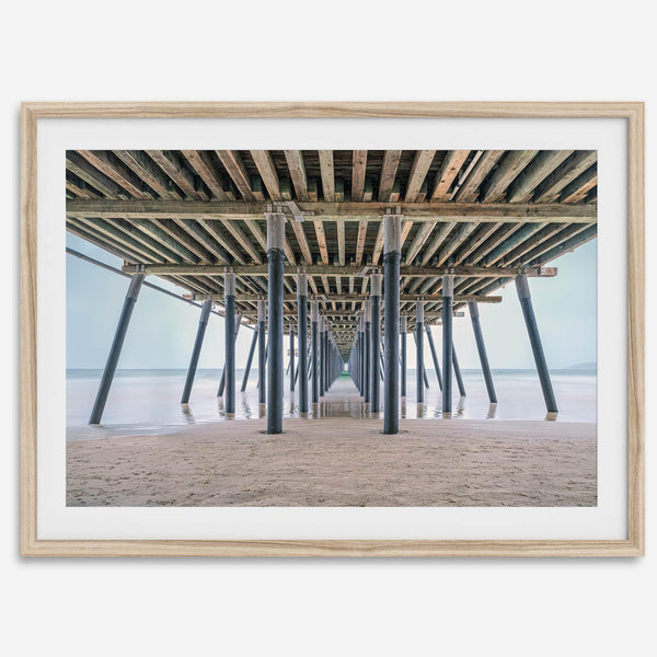 A fine art boho style beach photography print featuring a view from below Pismo Beach Pier.