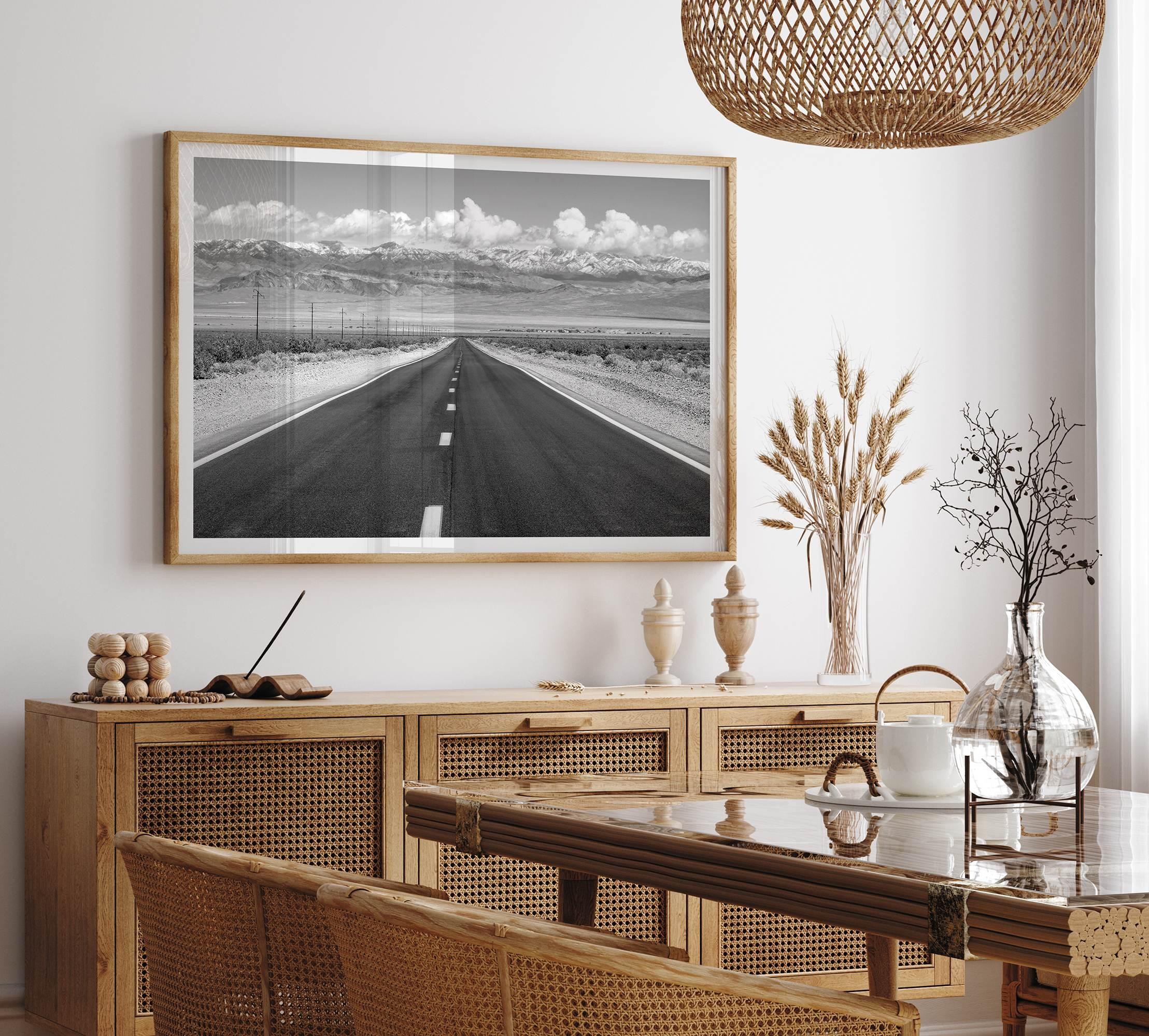 This stunning piece of black and white desert wall art will take your breath away. A beautifully framed picture of a Death Valley National Park road leading towards the snow-covered mountains at the end of the desert.