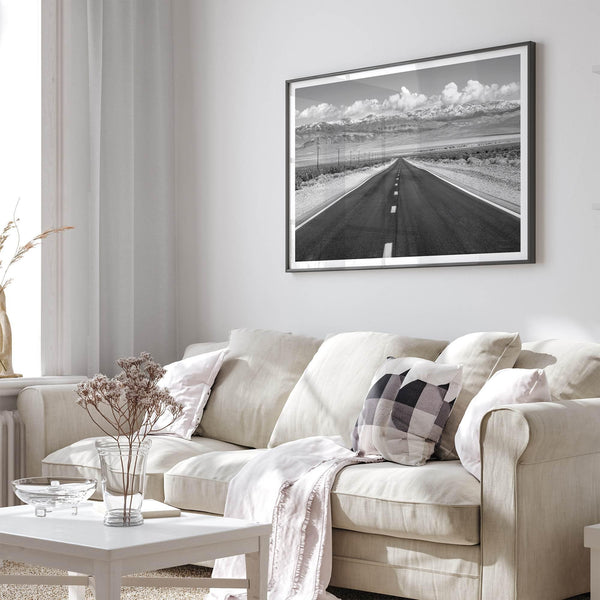 This stunning piece of black and white desert wall art will take your breath away. A beautifully framed picture of a Death Valley National Park road leading towards the snow-covered mountains at the end of the desert.