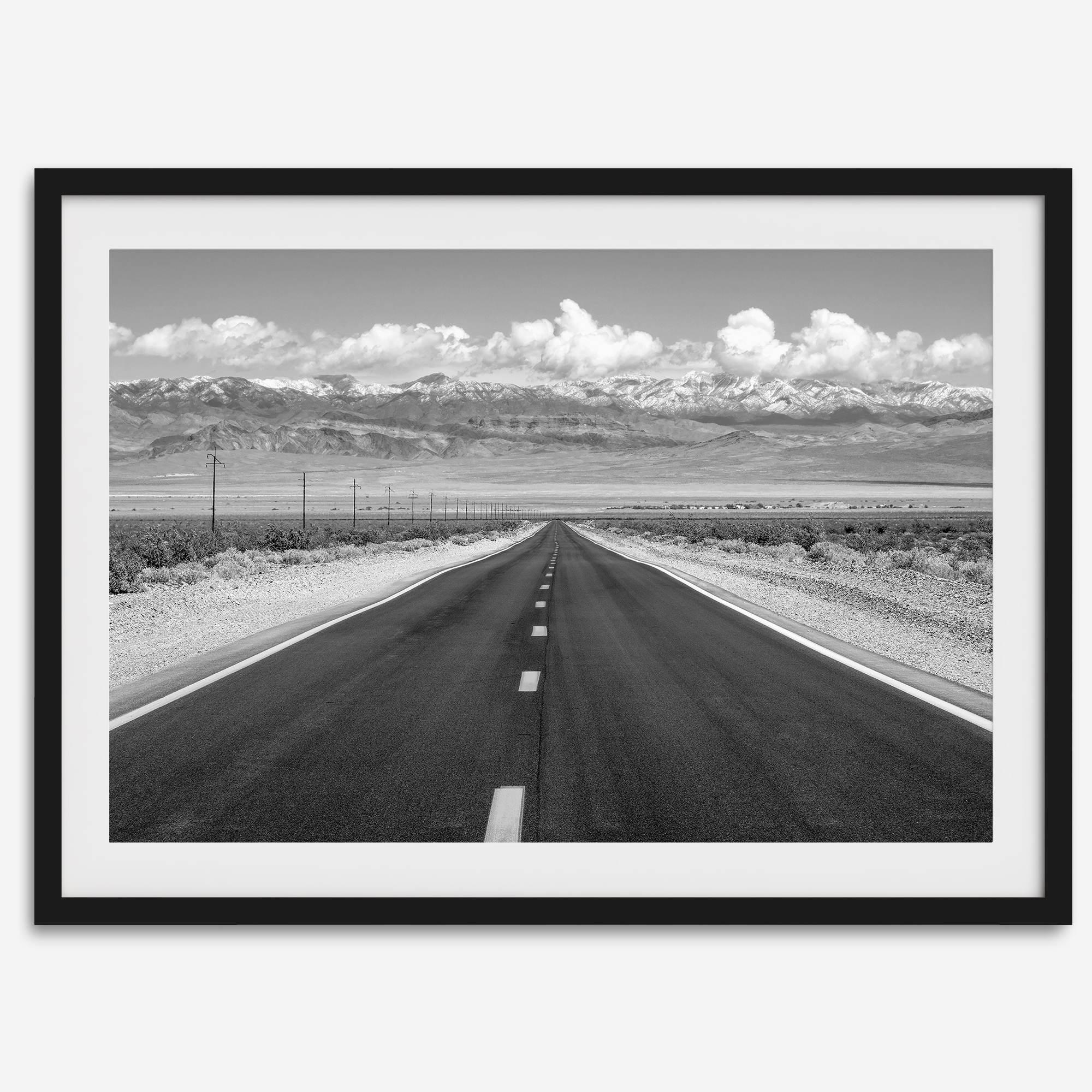 This stunning piece of black and white desert wall art will take your breath away. A beautifully framed picture of a Death Valley National Park road leading towards the snow-covered mountains at the end of the desert.