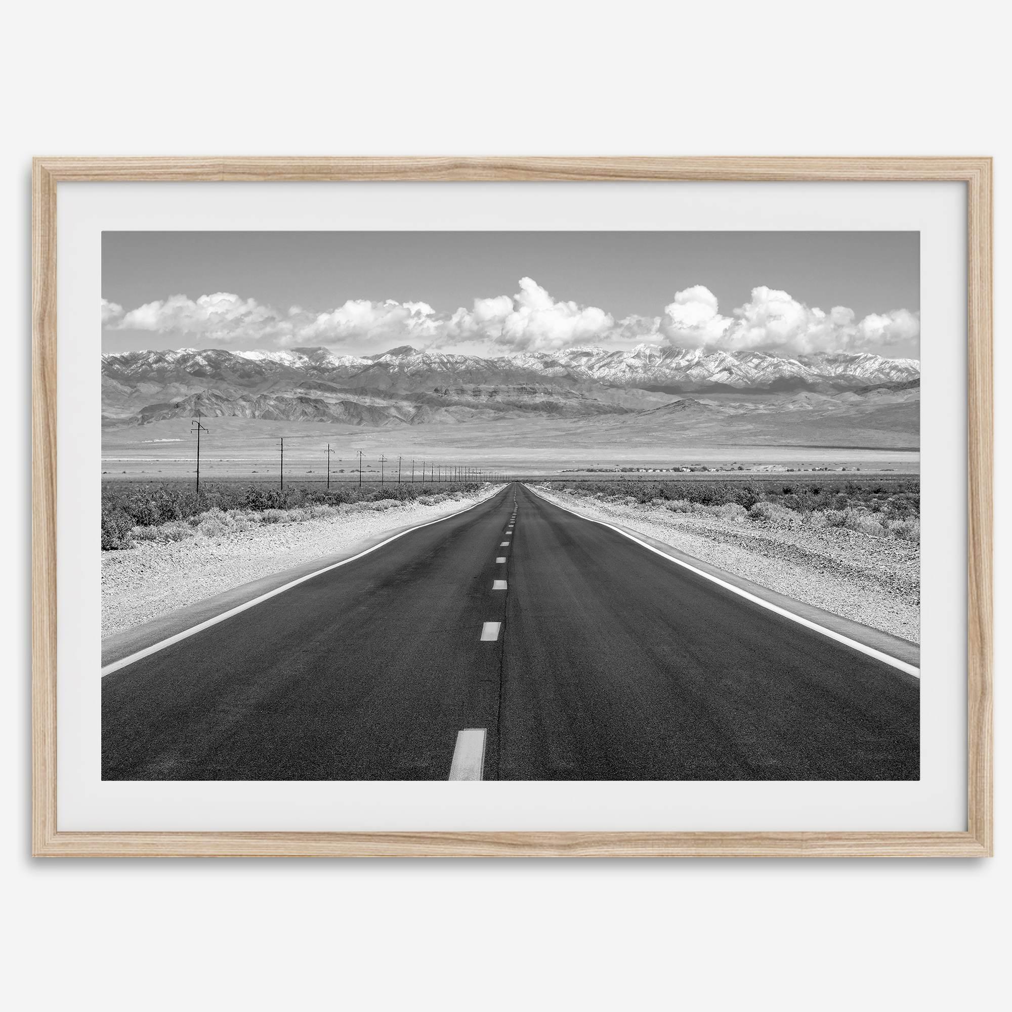 This stunning piece of black and white desert wall art will take your breath away. A beautifully framed picture of a Death Valley National Park road leading towards the snow-covered mountains at the end of the desert.