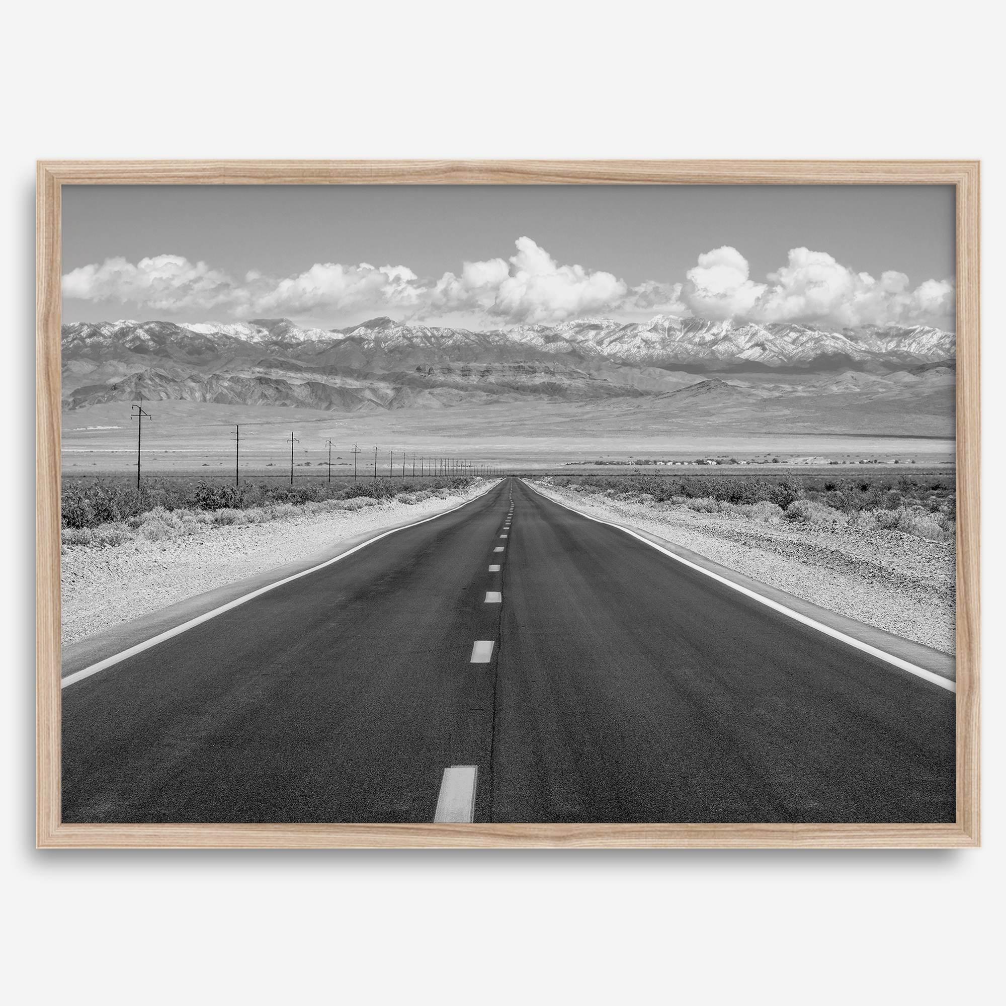 This stunning piece of black and white desert wall art will take your breath away. A beautifully framed picture of a Death Valley National Park road leading towards the snow-covered mountains at the end of the desert.