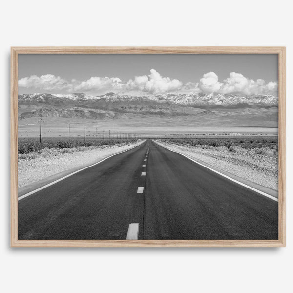 This stunning piece of black and white desert wall art will take your breath away. A beautifully framed picture of a Death Valley National Park road leading towards the snow-covered mountains at the end of the desert.