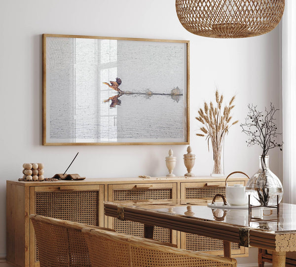 A fine art minimalist wildlife photography print showcasing a bird flying over a lake in Arizona.