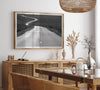 Black and white fine art photo of a winding desert road stretching through a vast minimalist landscape.