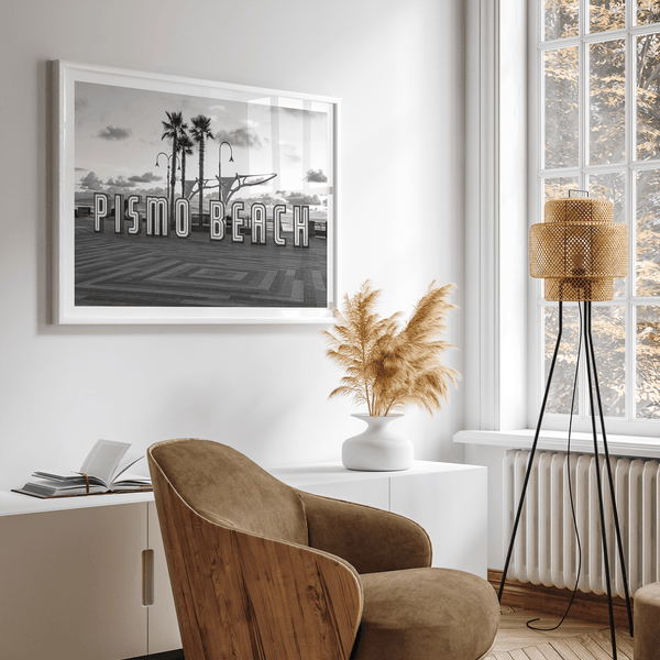 Black and white photo of the Pismo Beach street sign with palm trees and boardwalk – fine art coastal print