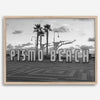 Black and white photo of the Pismo Beach street sign with palm trees and boardwalk – fine art coastal print