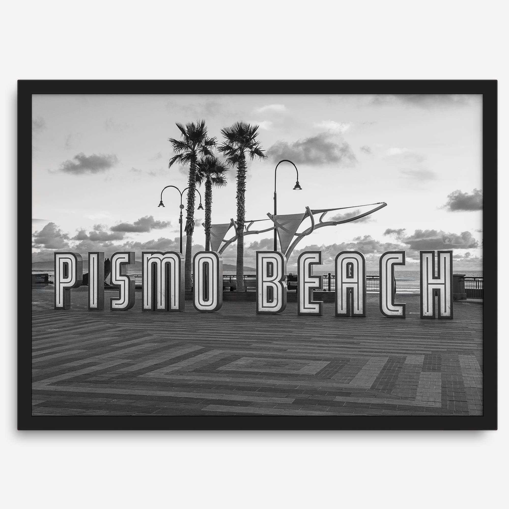 Black and white photo of the Pismo Beach street sign with palm trees and boardwalk – fine art coastal print
