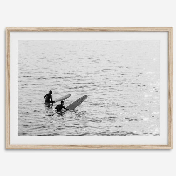 Black and white photo of two surfers with longboards waiting in calm ocean water – fine art surf photography print