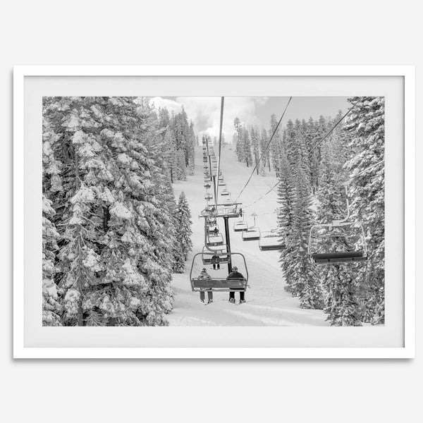 A fine art black and white mountain ski print showing a ski lift winding up the mountain with a stunning winter snow forest around it.