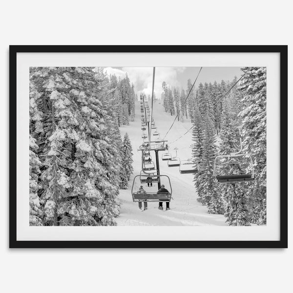 A fine art black and white mountain ski print showing a ski lift winding up the mountain with a stunning winter snow forest around it.