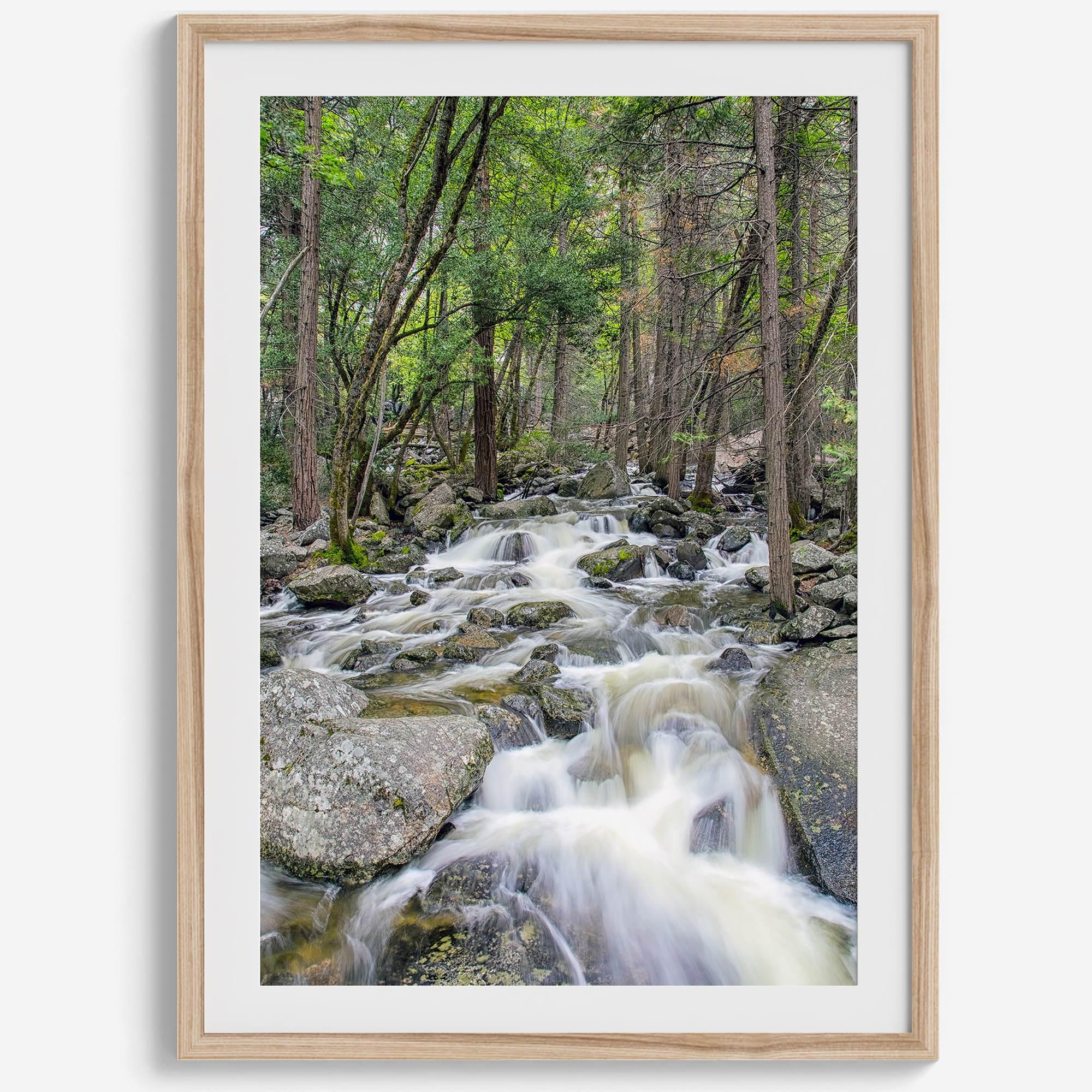 A beautiful river cuts through the forest, shot in long exposure making the water look creamy and calm in this fine art Yosemite National Park print.