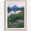 A fine art framed or unframed mountain print of Grand Teton National Park. This portrait orientation nature landscape wall art showcases the beautiful Teton mountains in a pink sunset, with Snake River and stunning flowers in the forefront.
