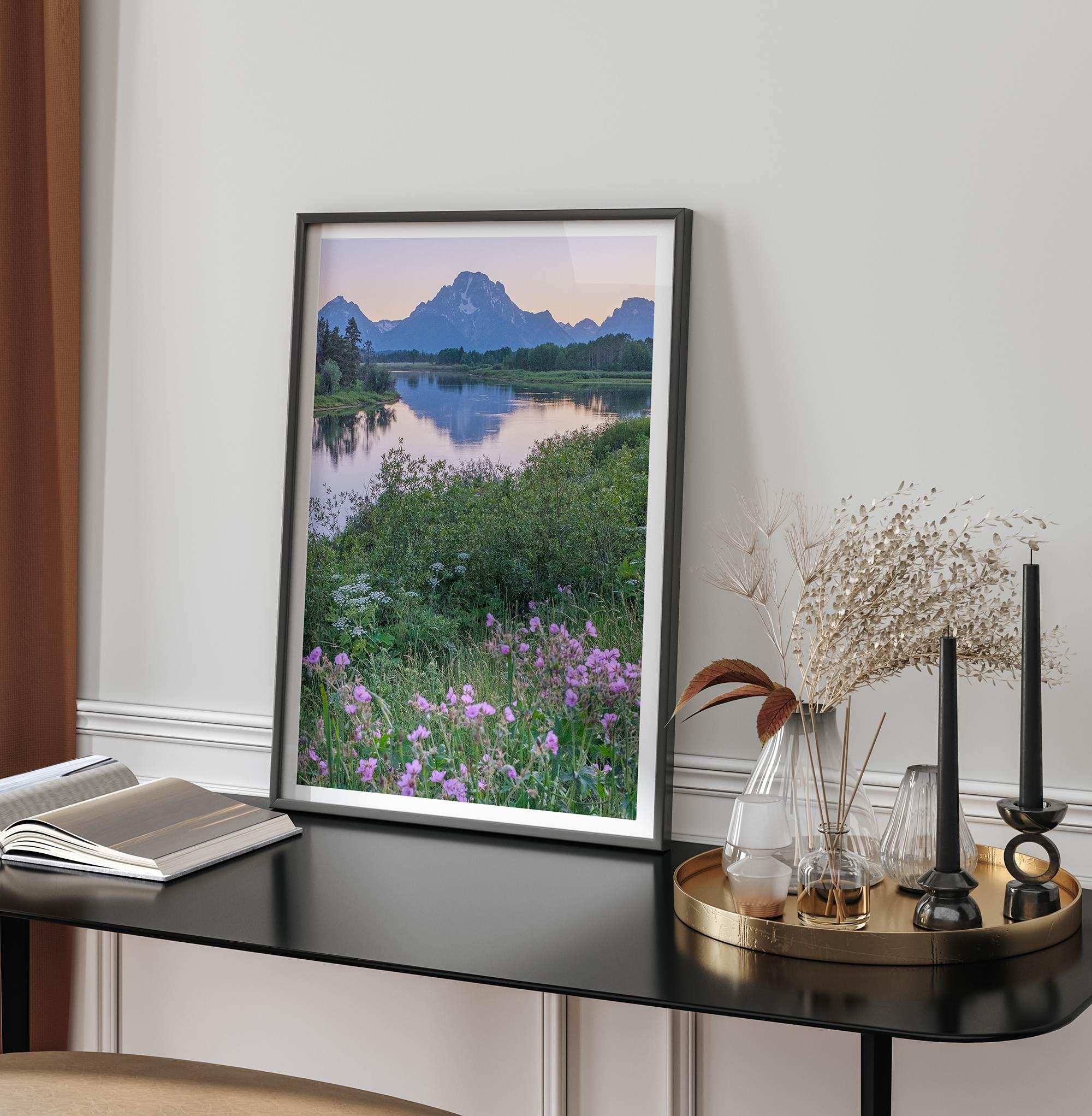 A fine art framed or unframed mountain print of Grand Teton National Park. This portrait orientation nature landscape wall art showcases the beautiful Teton mountains in a pink sunset, with Snake River and stunning flowers in the forefront.