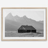 Step into Grand Teton National Park with this fine art black and white mountain print. This western landscape photo showcases a century-old rustic hut at the foot of the snowy, pointy Teton mountains.