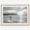 Surfer Wall Art featuring a lone surfer emerging from the ocean at Hanalei Bay in black-and-white photography.