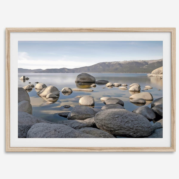 This breathtaking fine art Lake Tahoe print captures the perfect shape of the huge rocks that rise from the crystal-clear water, creating a beautiful contrast against the blue sky and the distant mountain range.