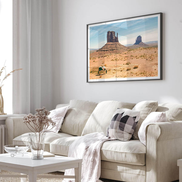 A framed or unframed fine art photography desert print of a horse in Monument Valley, Utah. This wall art features unique rock formations native to the Monument Valley area. This horse wall art comes in different sizes, including extra large.