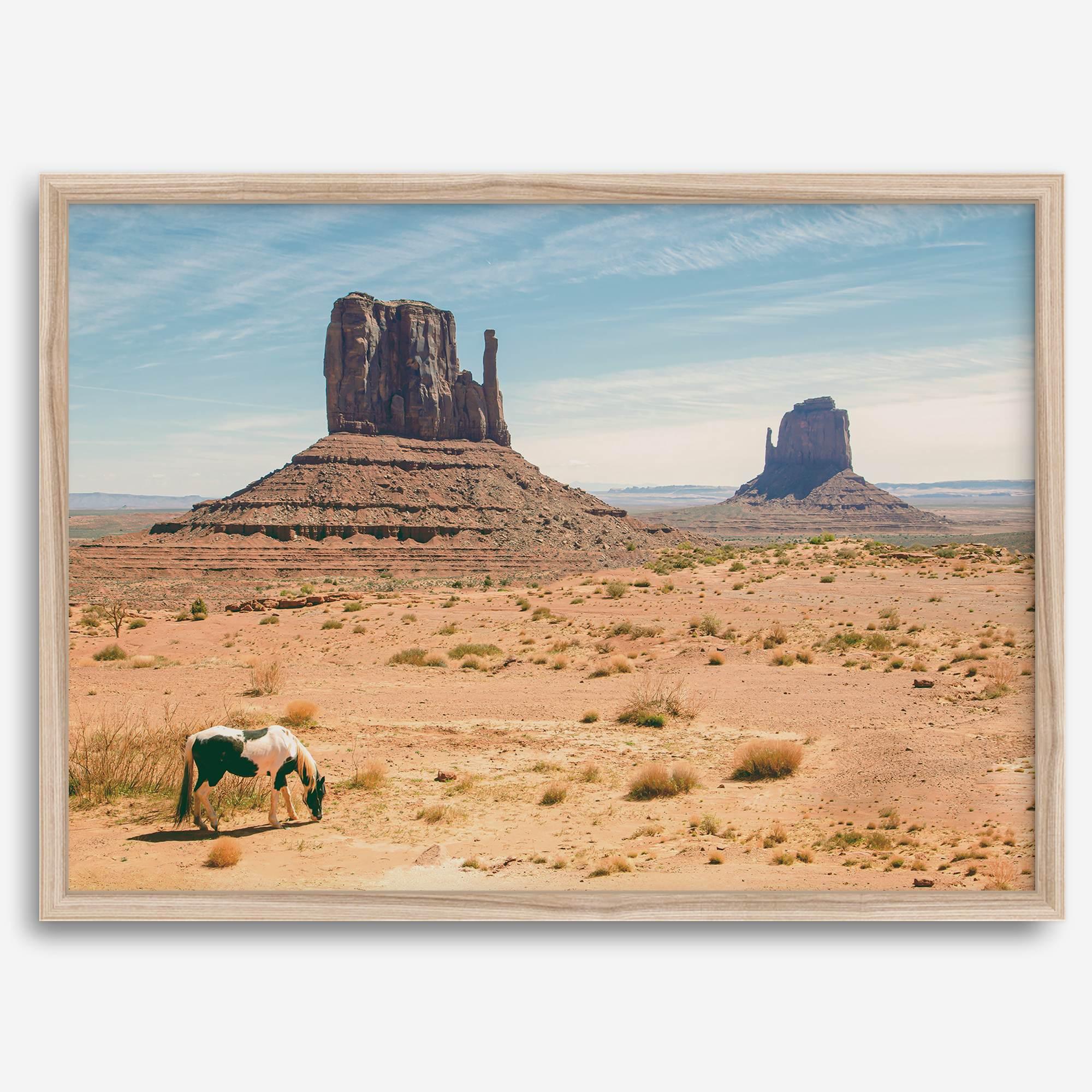 A framed or unframed fine art photography desert print of a horse in Monument Valley, Utah. This wall art features unique rock formations native to the Monument Valley area. This horse wall art comes in different sizes, including extra large.