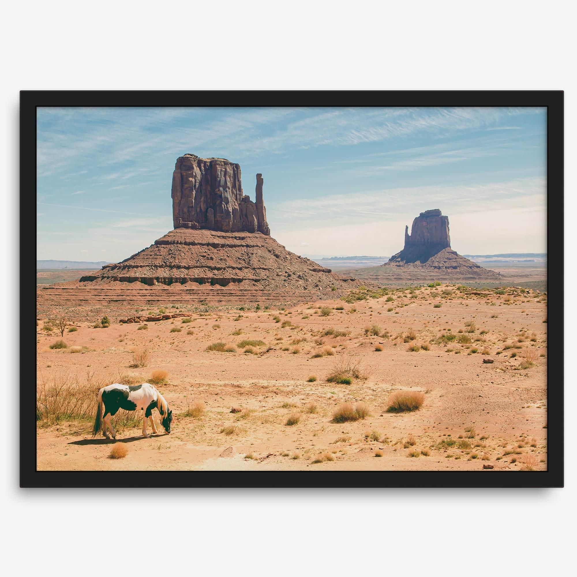 A framed or unframed fine art photography desert print of a horse in Monument Valley, Utah. This wall art features unique rock formations native to the Monument Valley area. This horse wall art comes in different sizes, including extra large.