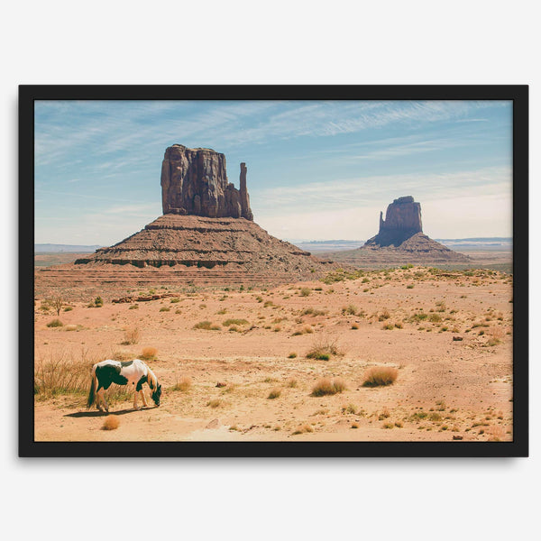 A framed or unframed fine art photography desert print of a horse in Monument Valley, Utah. This wall art features unique rock formations native to the Monument Valley area. This horse wall art comes in different sizes, including extra large.