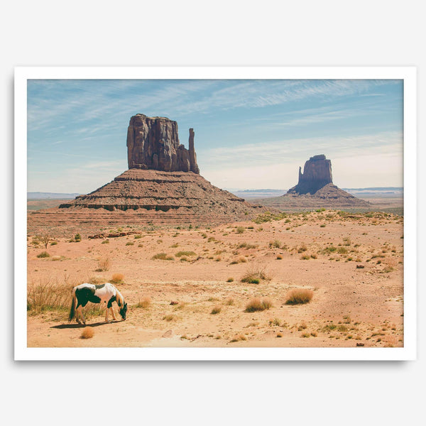 A framed or unframed fine art photography desert print of a horse in Monument Valley, Utah. This wall art features unique rock formations native to the Monument Valley area. This horse wall art comes in different sizes, including extra large.