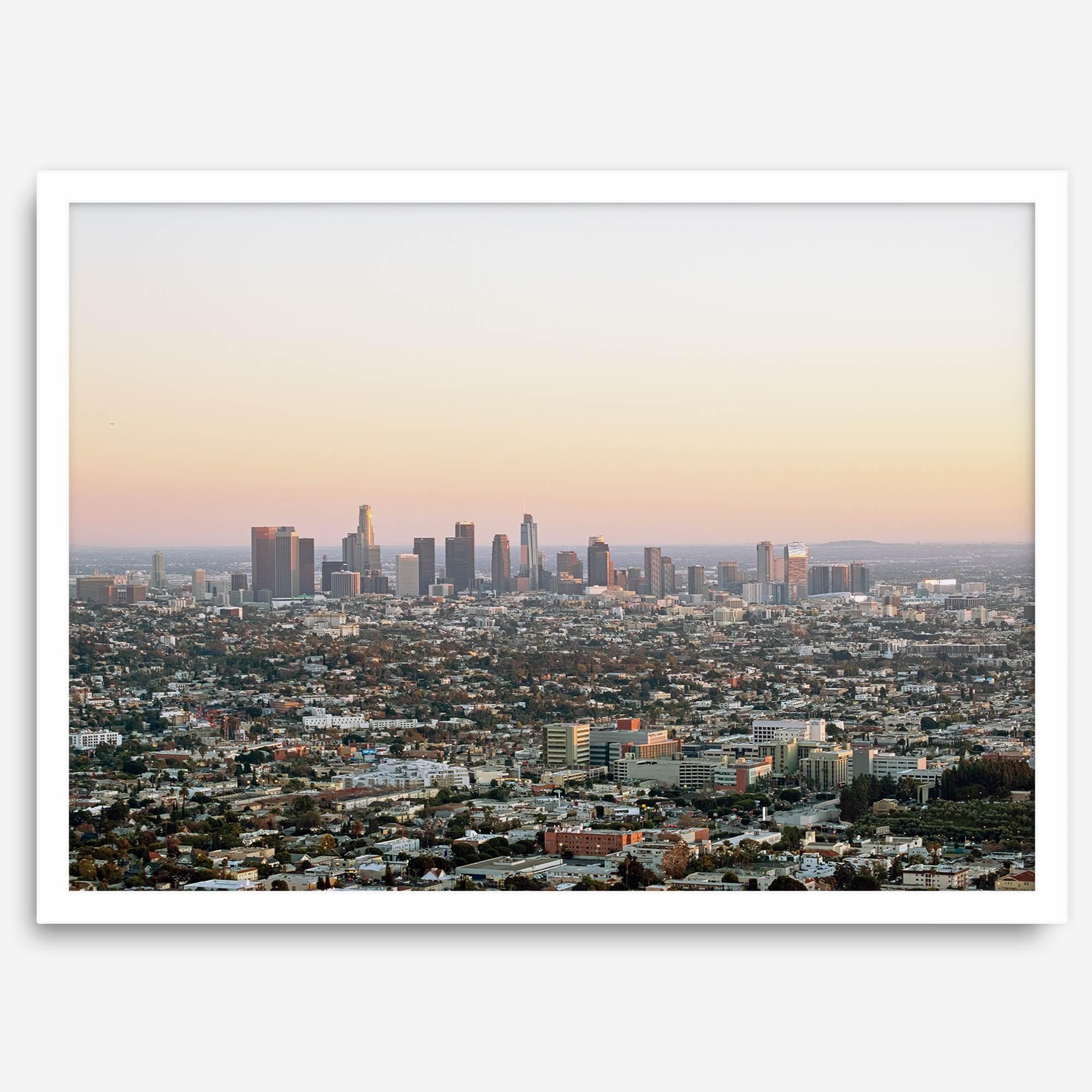 Los Angeles cityscape bathed in a vibrant sunset, showcasing the city's iconic buildings from above