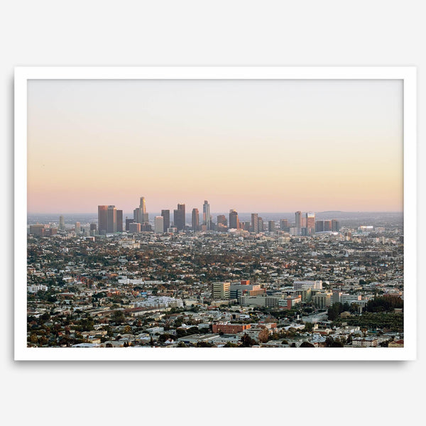 Los Angeles cityscape bathed in a vibrant sunset, showcasing the city's iconic buildings from above
